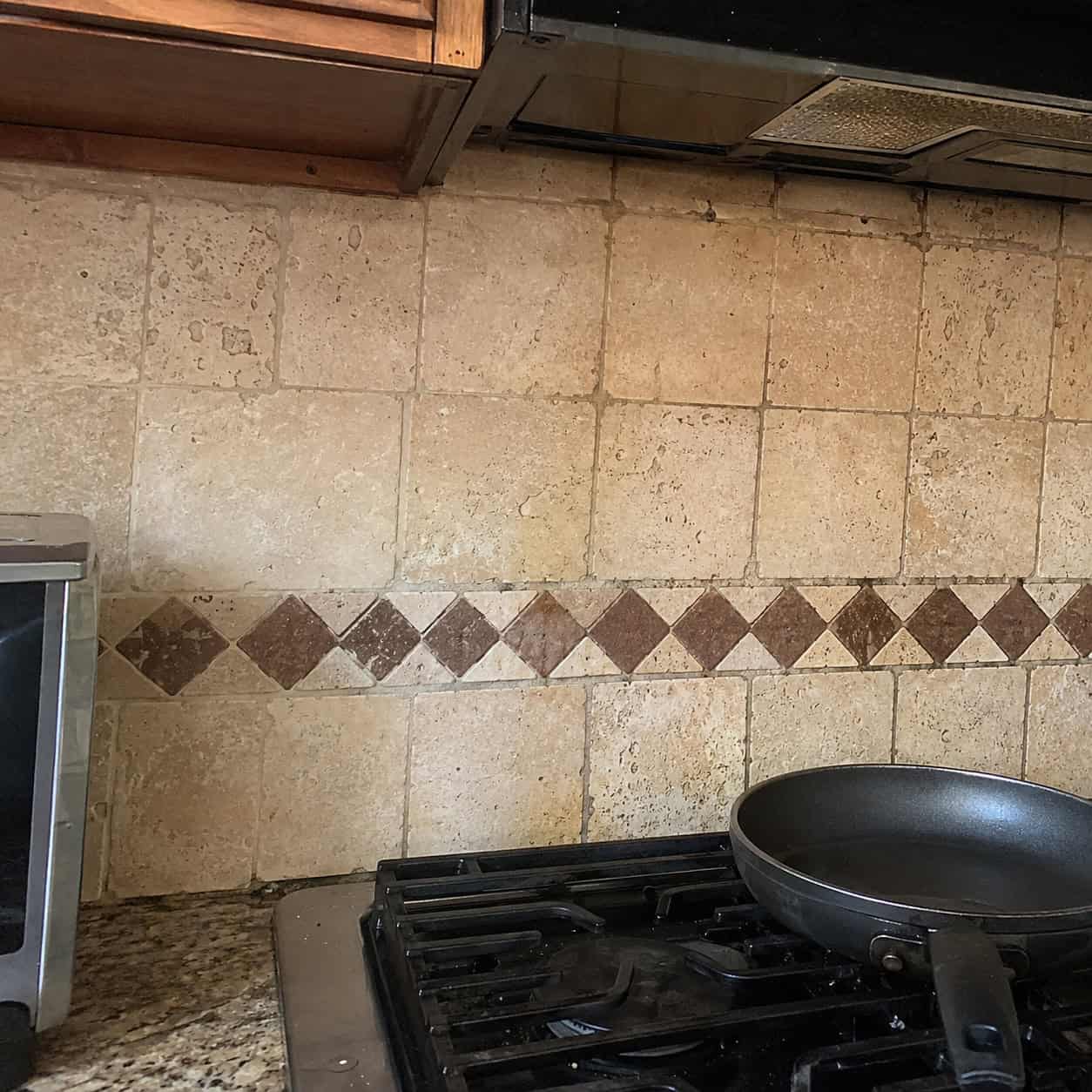 Tumbled travertine backsplash with accent dots