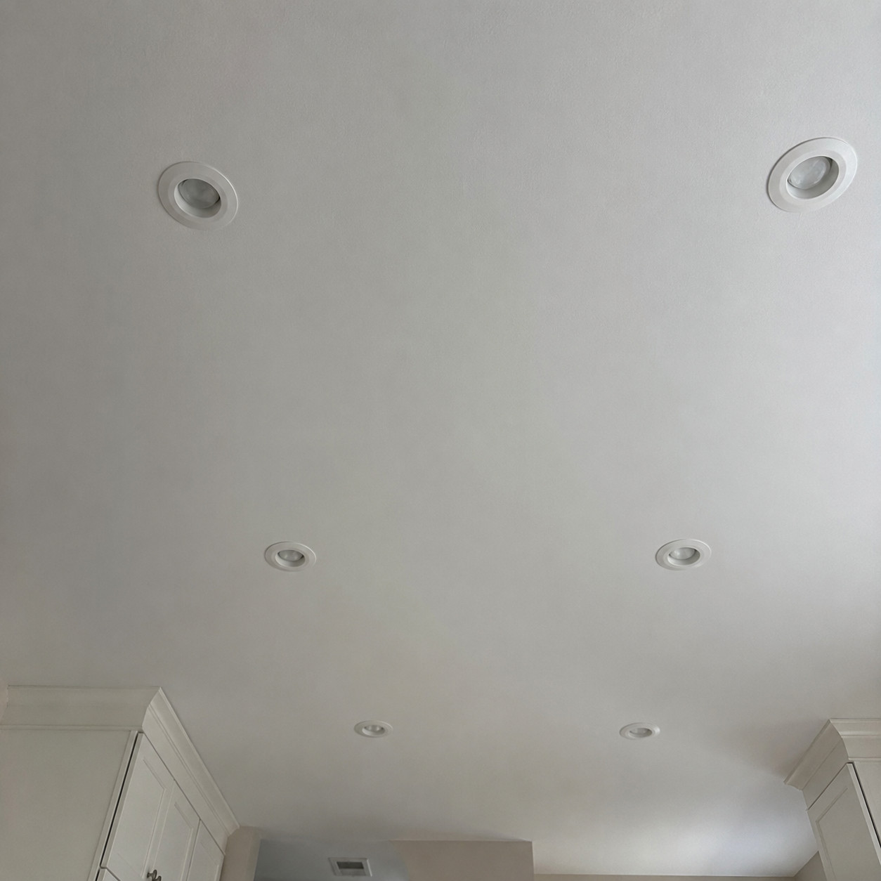 A grid of recessed can lights