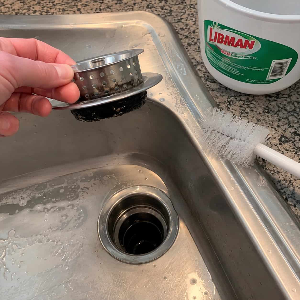 Unscrewing the Sink Strainer Basket and Scrubbing It by Hand