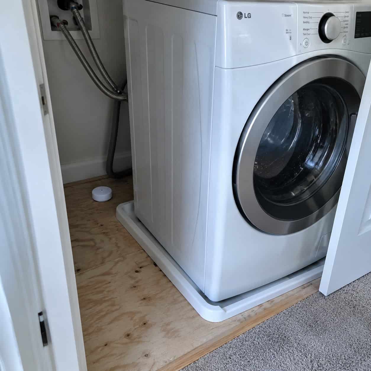 An Upstairs Washer Sitting on Bare Subfloor