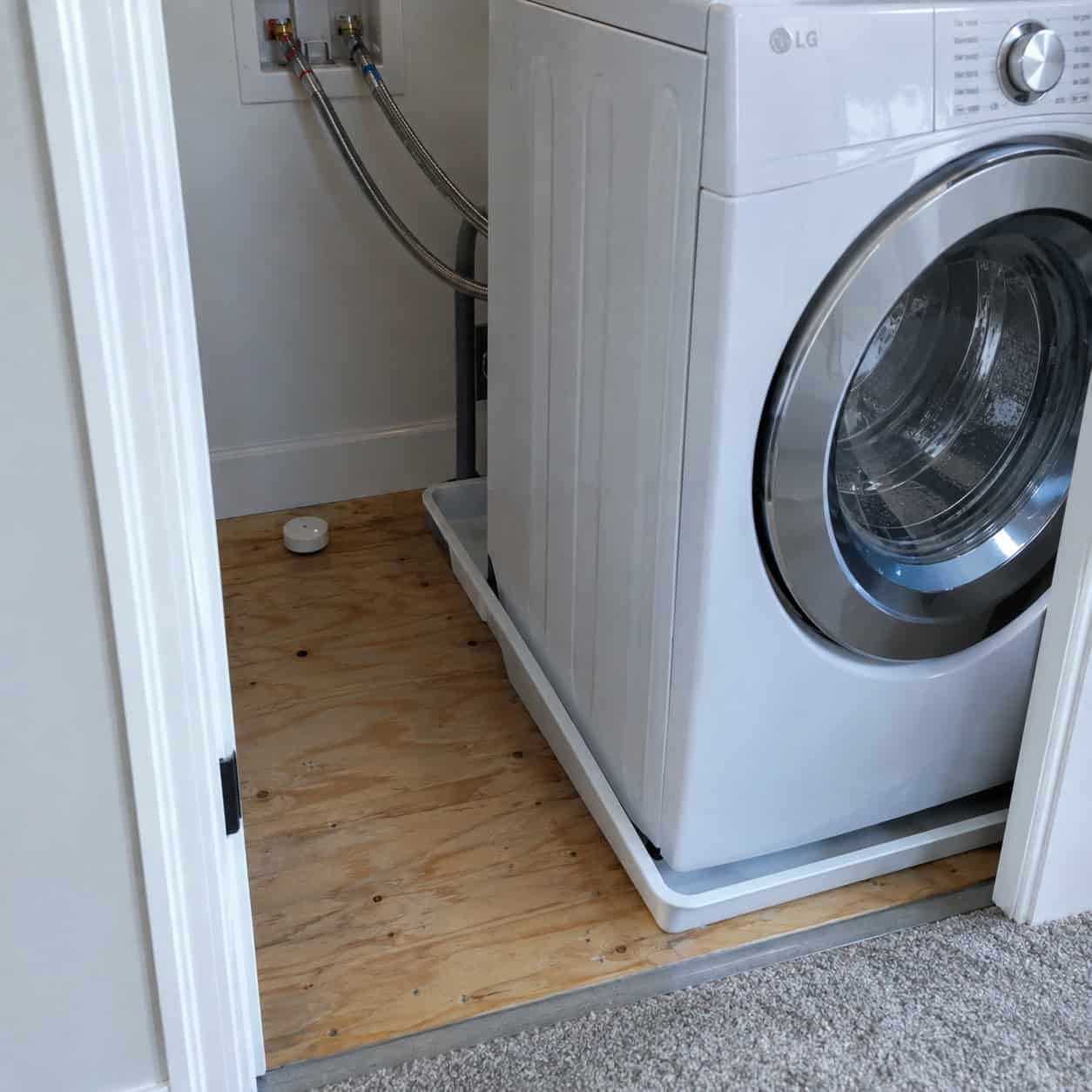 An Upstairs Washer Sitting on Bare Subfloor