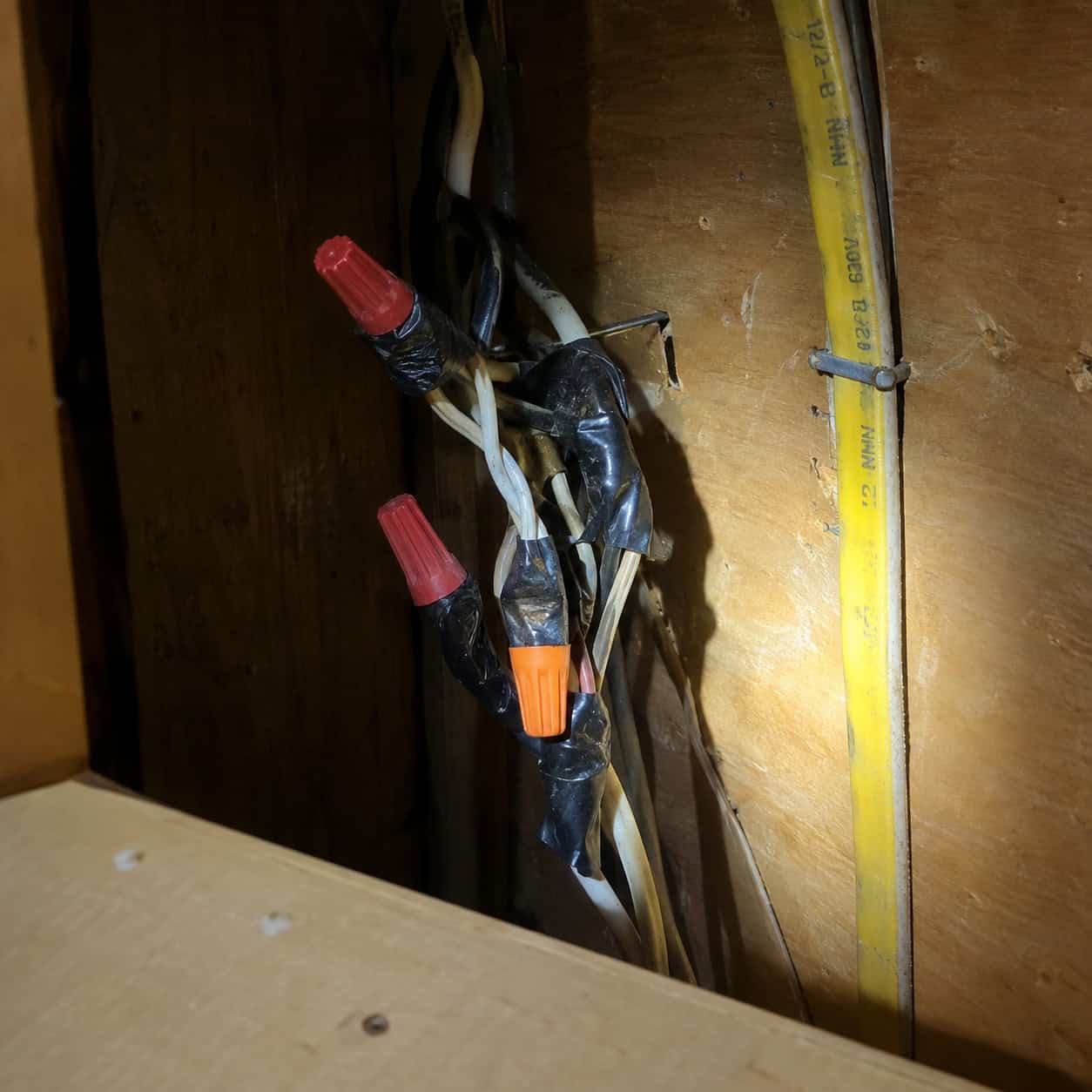A junction box buried behind a cabinet